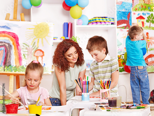 Photo: Child painting at easel. Child painting at easel.