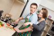 Man in striped apron cuts vegetables for dinner