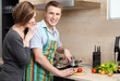 Man in striped apron slices vegetables for dinner