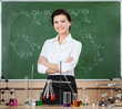Smiley chemistry teacher surrounded with chemical glassware