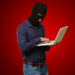 young male thief holding laptop