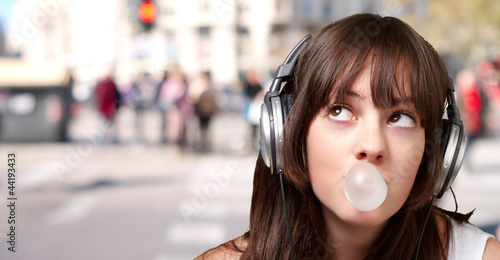 Photo: portrait of young woman listening to music with bubble gum again portrait of young woman listening to music with bubble gum again
