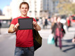 portrait of young man holding a digital tablet at street