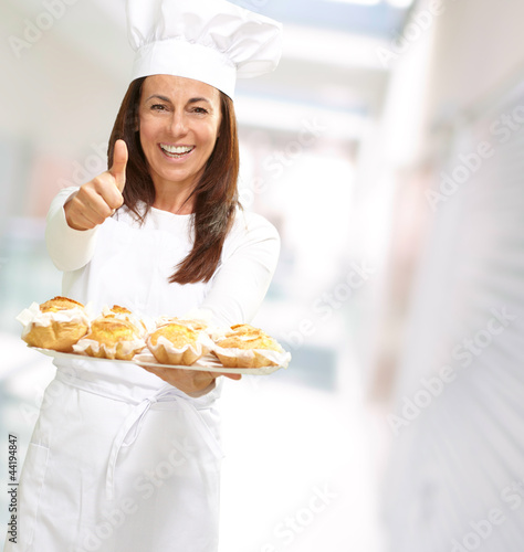 Photo: Woman chef holding baked food Woman chef holding baked food