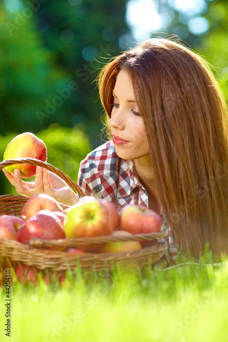 Photo: Beautiful woman in the garden with apples Beautiful woman in the garden with apples