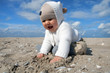 Happy baby girl sitting on a beach
