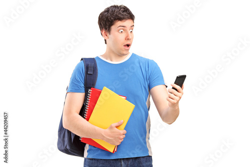 Photo: A surprised teenager looking at a mobile phone A surprised teenager looking at a mobile phone