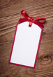 address card with bow on old wooden background.