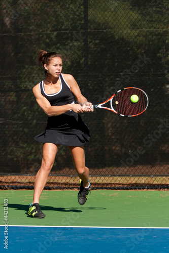 Photo: Female Tennis Player Hits Backhand Female Tennis Player Hits Backhand