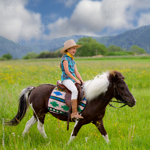 Photo: Horse riding - lovely girl is riding a pony Horse riding - lovely girl is riding a pony