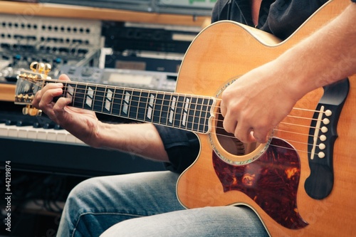 Photo: left-handed man playing guitar, close-up left-handed man playing guitar, close-up