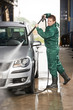 worker cleaning car with pressured water