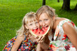mother and daughter eating watermelon