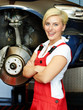 Female apprentice in a garage learning to fix a brake