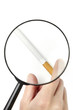 Hand taking cigarette viewed through magnifying glass