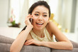 Young Chinese Woman Using Mobile Phone On Sofa At Home