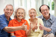 Group Of Senior Chinese Friends Relaxing On Sofa At Home