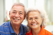 Senior Chinese Couple Relaxing On Sofa At Home