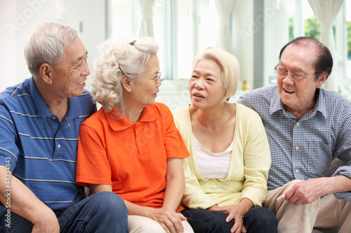 Photo: Group Of Senior Chinese Friends Relaxing On Sofa At Home Group Of Senior Chinese Friends Relaxing On Sofa At Home
