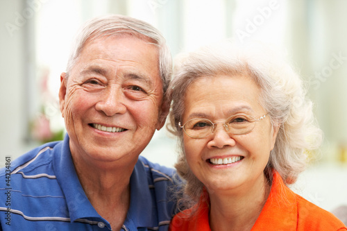 Photo: Senior Chinese Couple Relaxing On Sofa At Home Senior Chinese Couple Relaxing On Sofa At Home
