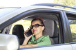 Cute woman talking on tablet phone in the car