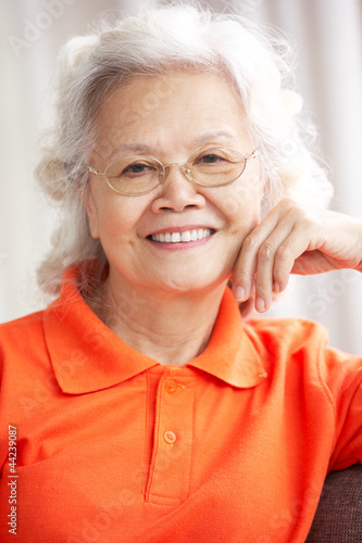 Photo: Senior Chinese Woman Relaxing On Sofa At Home Senior Chinese Woman Relaxing On Sofa At Home