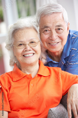 Photo: Senior Chinese Couple Relaxing On Sofa At Home Senior Chinese Couple Relaxing On Sofa At Home