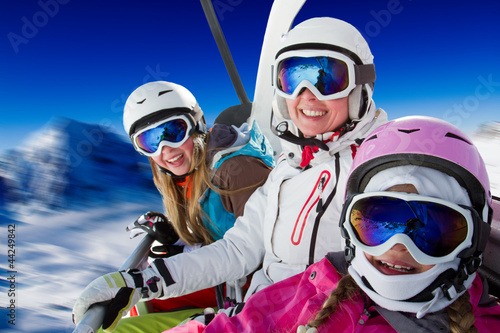 Photo: Skiing, winter - happy family ski team on ski lift Skiing, winter - happy family ski team on ski lift