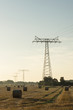 Energienetz auf Feld mit Strohballen im Morgenlicht