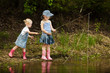 Little girls are fishing on lake in forest