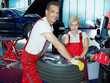 Two motor mechanics fitting a summer tyre