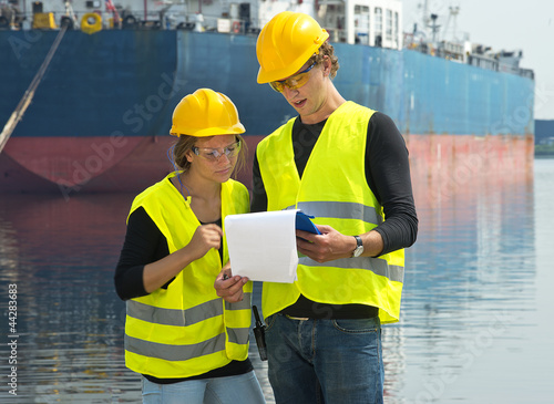 Photo: Dockers checking freight papers Dockers checking freight papers