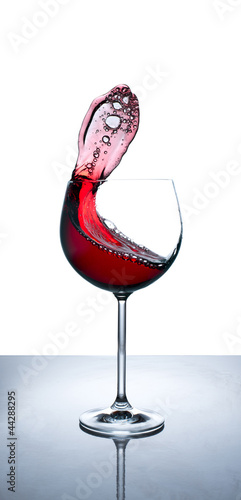 Photo: Rotwein schwappt aus Rotweinglas Rotwein schwappt aus Rotweinglas