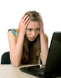 girl with horror looks at the laptop screen