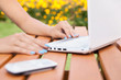 Woman with laptop and smartphone in the garden