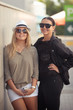 Two fashion woman standing outdoor and smiling