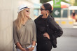 Two fashion woman standing outdoor and smiling