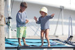 Photo: two cute children in sailor t-shirt on sea catamaran / yacht two cute children in sailor t-shirt on sea catamaran / yacht