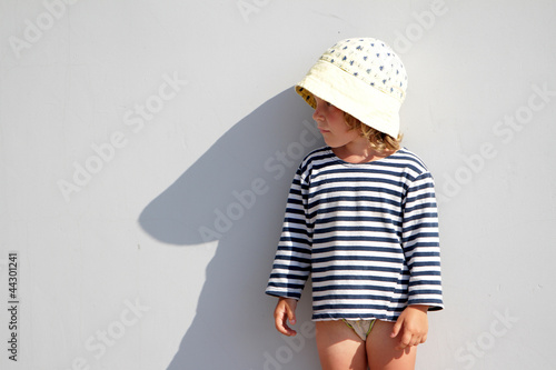 Photo: young girl standing next to grey wall and making shadow young girl standing next to grey wall and making shadow