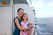 smiling mother and daughter traveling on big cruise ship
