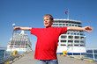 little boy spread hands against background two ships