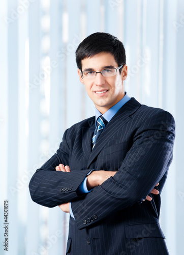 Photo: Portrait of smiling businessman at office Portrait of smiling businessman at office