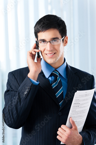Photo: Businessman with cellphone and documents Businessman with cellphone and documents