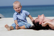 Photo: outdoor portrait of young mother and child on blue sky backgroun outdoor portrait of young mother and child on blue sky backgroun