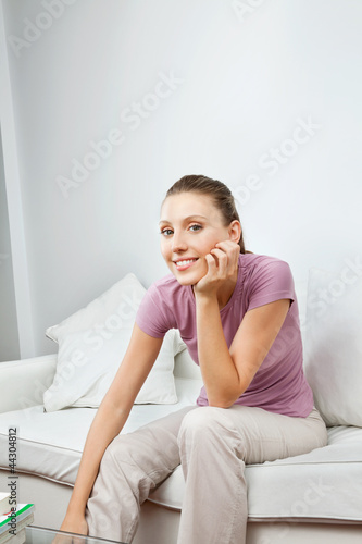 Photo: Pretty Woman Sitting On Sofa Pretty Woman Sitting On Sofa