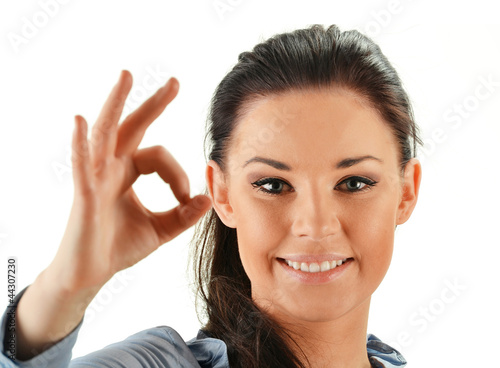 Photo: Young attractive woman showing ok isoleated on white Young attractive woman showing ok isoleated on white