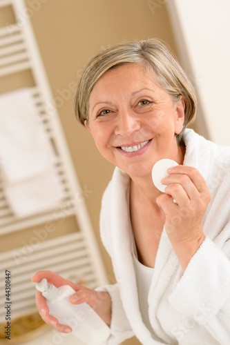 Photo: Senior woman hold cotton pad make-up removal Senior woman hold cotton pad make-up removal