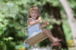 young happy girl on swing on natural background