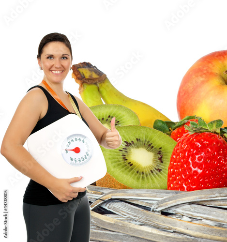 Foto: young woman with a weight scale and fresh fruit young woman with a weight scale and fresh fruit