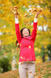 Happy fall woman throwing leaves